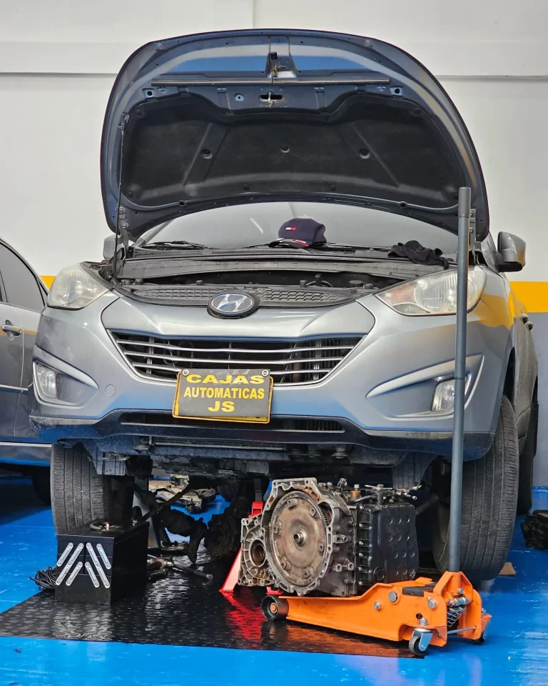 Vehículo Hyundai con la caja automática desmontada y colocada en el piso del taller.